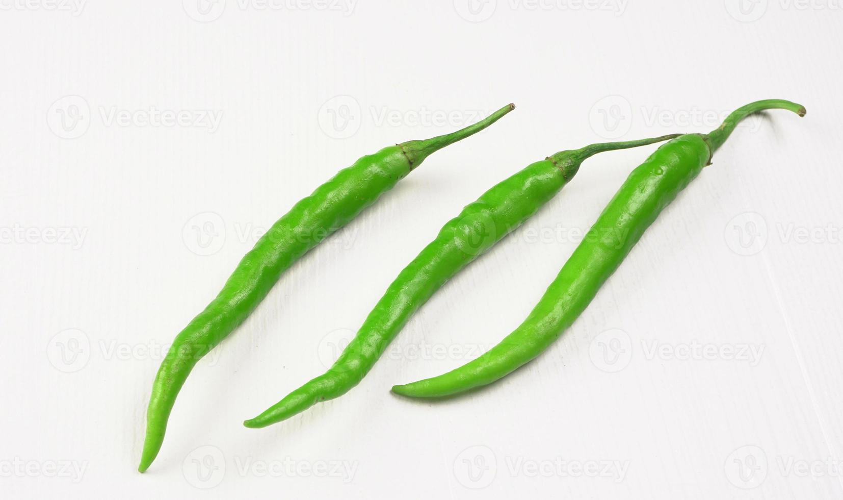 färska långa indiska gröna chili på trä bakgrund. foto