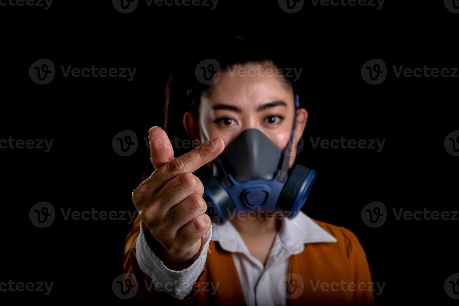 affärskvinna från ung asiatisk kvinna som sätter på sig en andningsmask n95 för att skydda mot luftburna luftvägssjukdomar som influensa covid-19 coronavirus pm2.5 damm och smog, kvinnor handtecken minihjärta foto