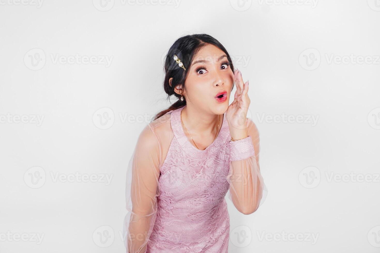 en ung skön asiatisk kvinna är skrikande och skrikande högt med en hand på henne mun, isolerat förbi vit bakgrund. foto
