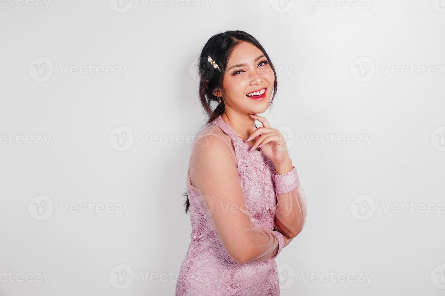 ett attraktiv asiatisk kvinna bär rosa klänning är leende till de kamera, isolerat förbi vit bakgrund. foto