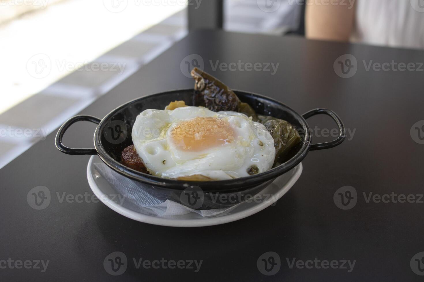 en tapa av friterad potatisar, friterad ägg, chistorra och friterad grön peppar. spanska mat begrepp. foto