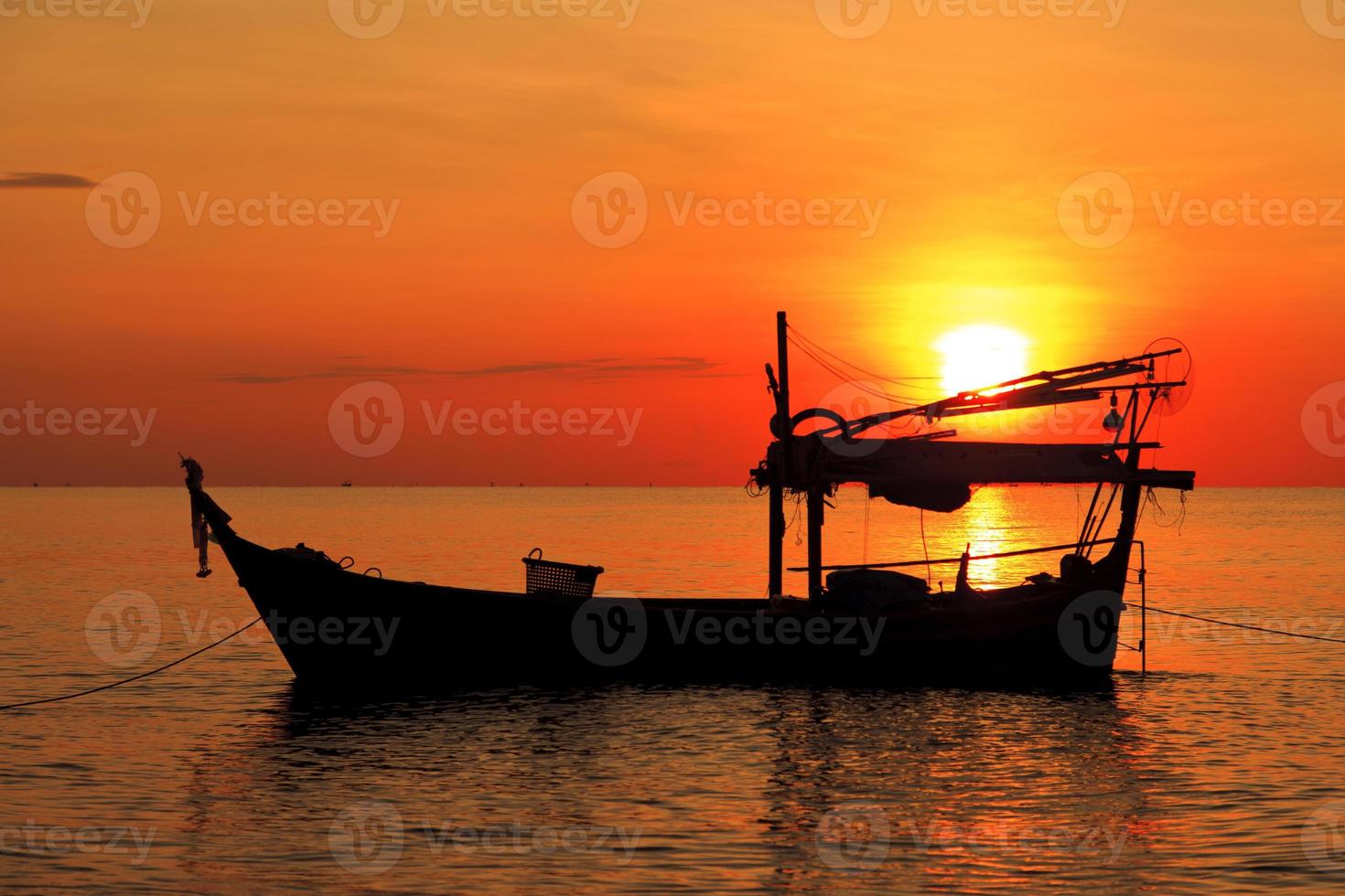 silhuett av fiskebåt vid solnedgången foto