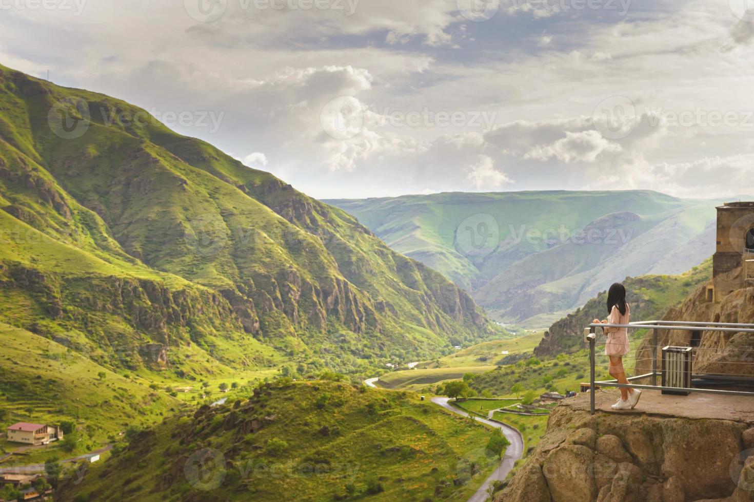 kvinnlig turistställning på panoramautsikt över grottstaden Vardzia med en fantastisk kanjon i bakgrunden foto