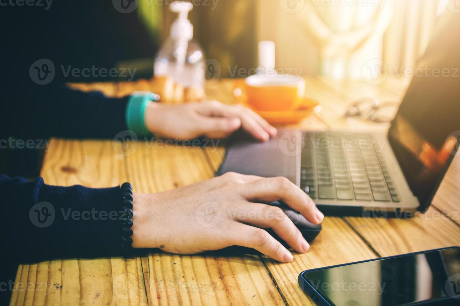kvinnor använder sig av bärbar dator arbetssätt rena händer med alkohol och dryck kaffe kopp varm i de morgon- foto