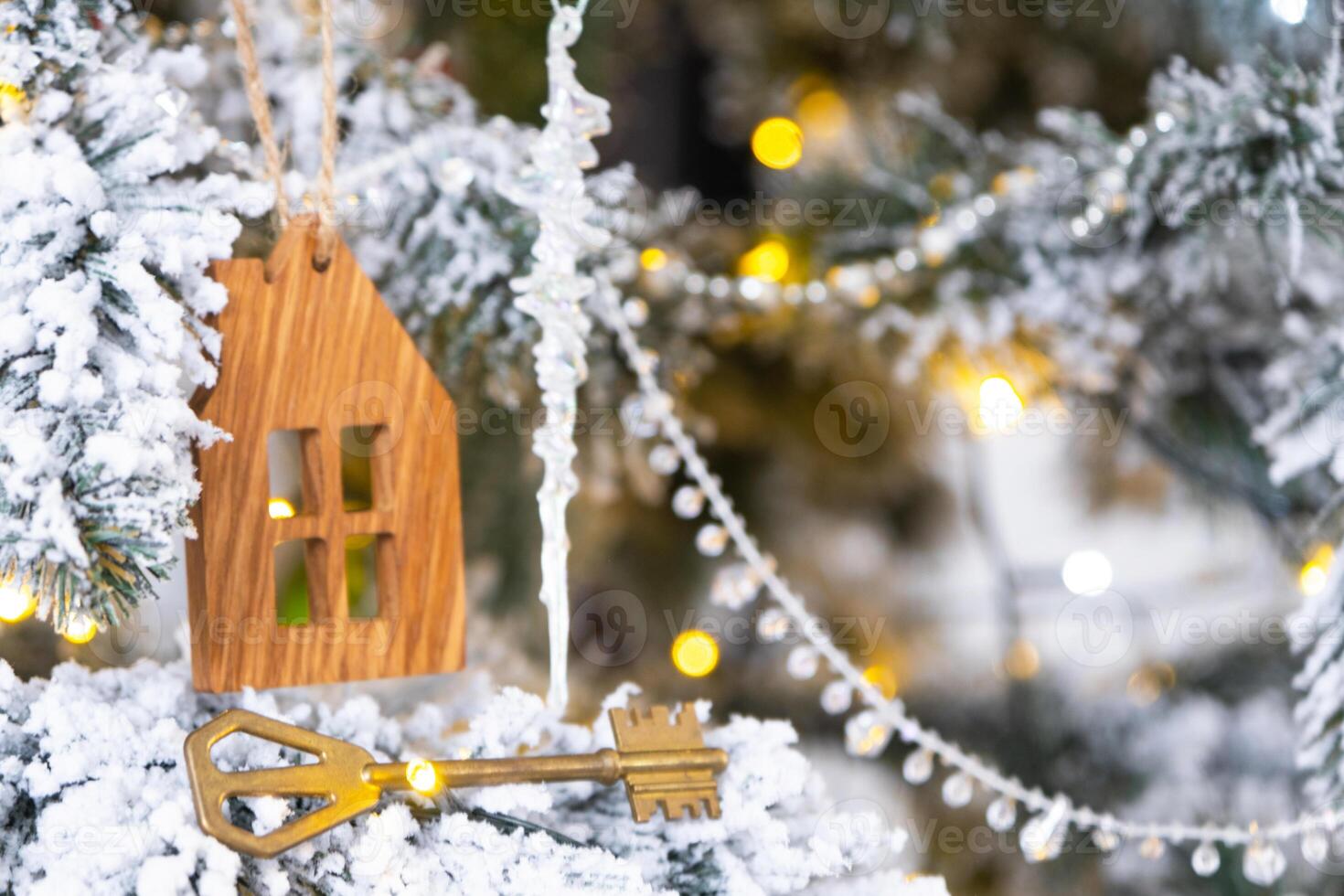 nyckel och mycket liten hus Nyckelring i hand på bakgrund fe- lampor jul träd. gåva för ny år, jul. byggnad, design, projekt, rör på sig, försäkring, inteckning, hyra och inköp verklig egendom. foto