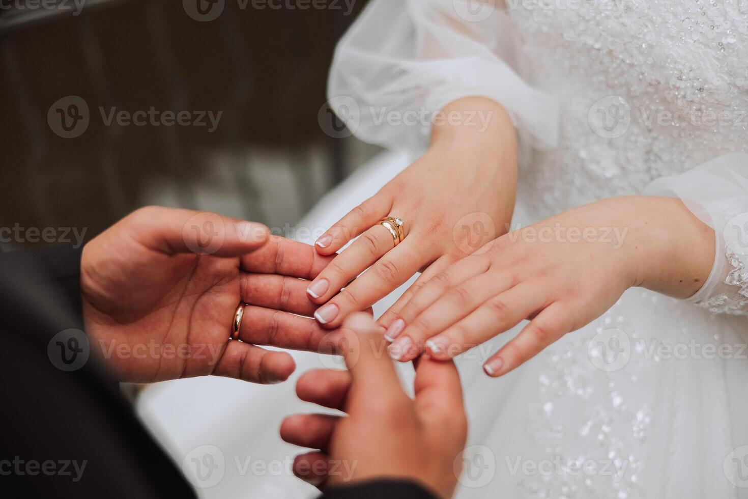 de brudgum innehar de brudens hand. beskurna Foto. guld bröllop ringar. detaljer foto