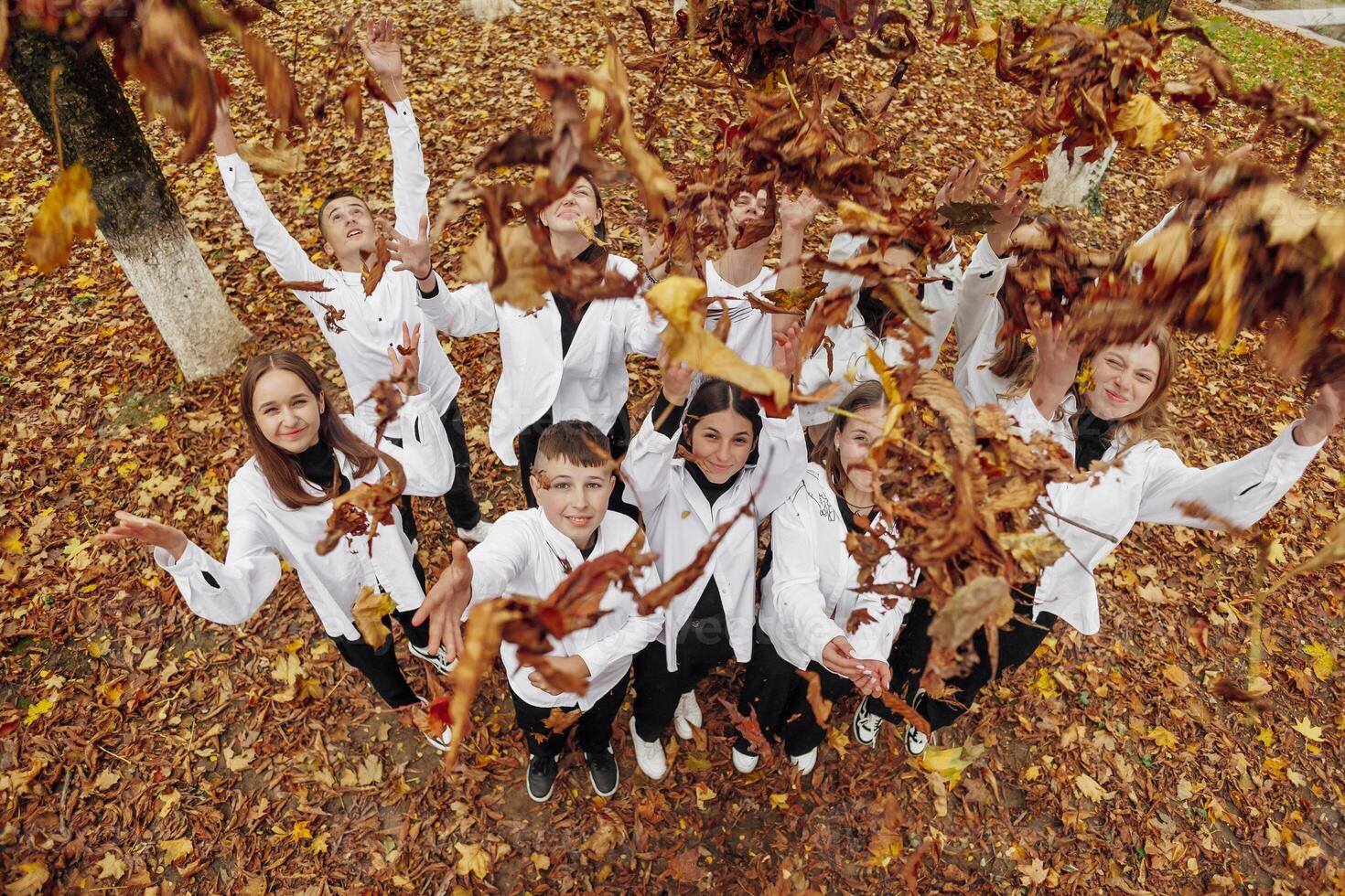 vänskap, rörelse, handling, frihet och människor begrepp - grupp av Lycklig tonåringar eller skola vänner Framställ och har roligt utomhus mot natur eller skog bakgrund. foto