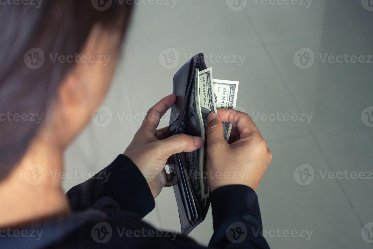 kvinna som tar ut dollarsedlar från plånboken foto