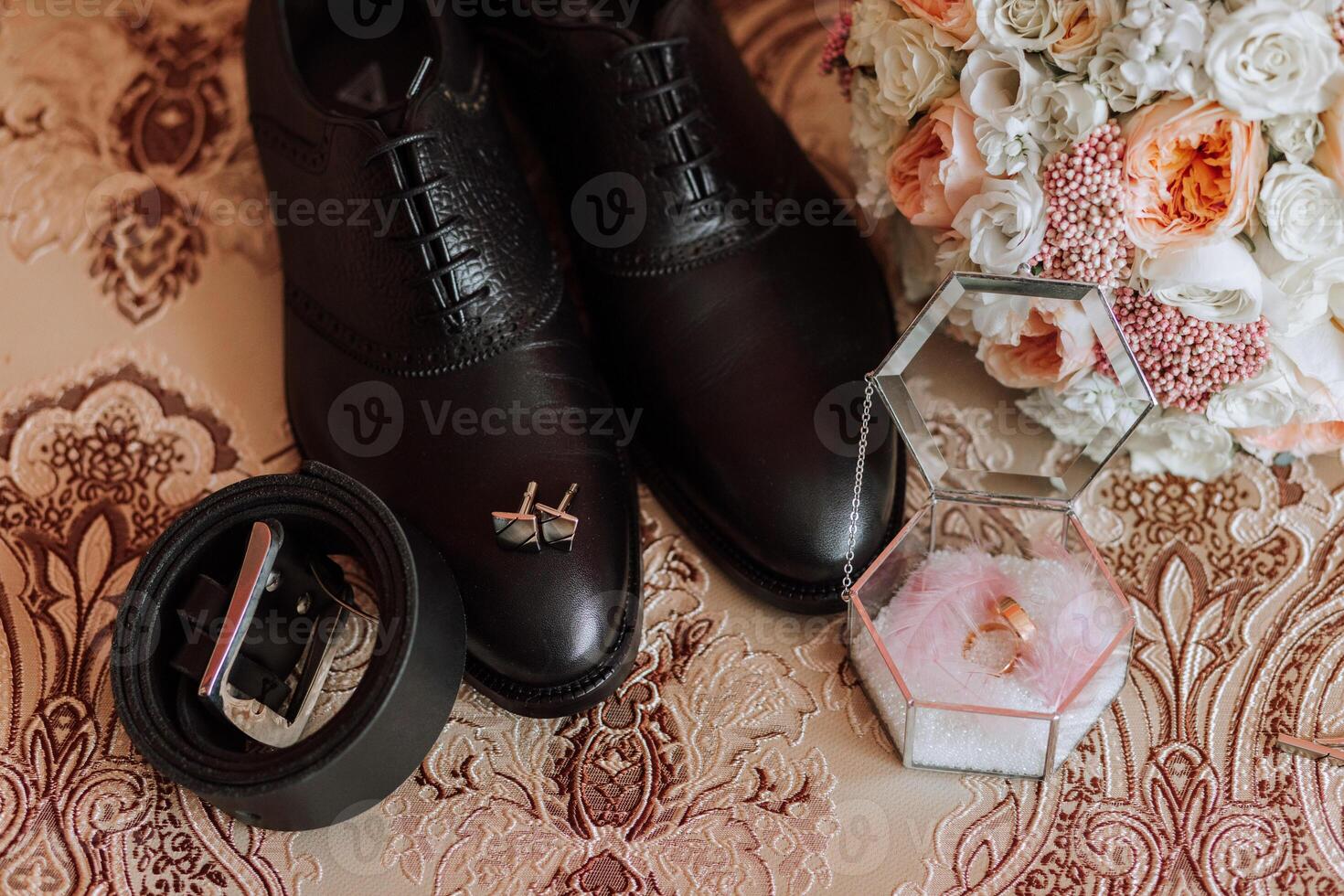 herr- Tillbehör, brudgum detaljer platt lägga. svart skor, guld bröllop ringar, en bröllop bukett av blommor foto