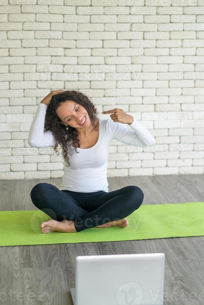 latinsk kvinna som undervisar i yoga online foto