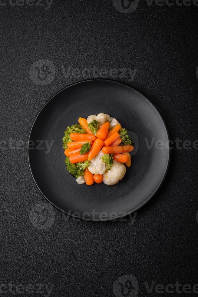 utsökt färsk grönsaker broccoli, blomkål, morötter ångad med salt och kryddor foto