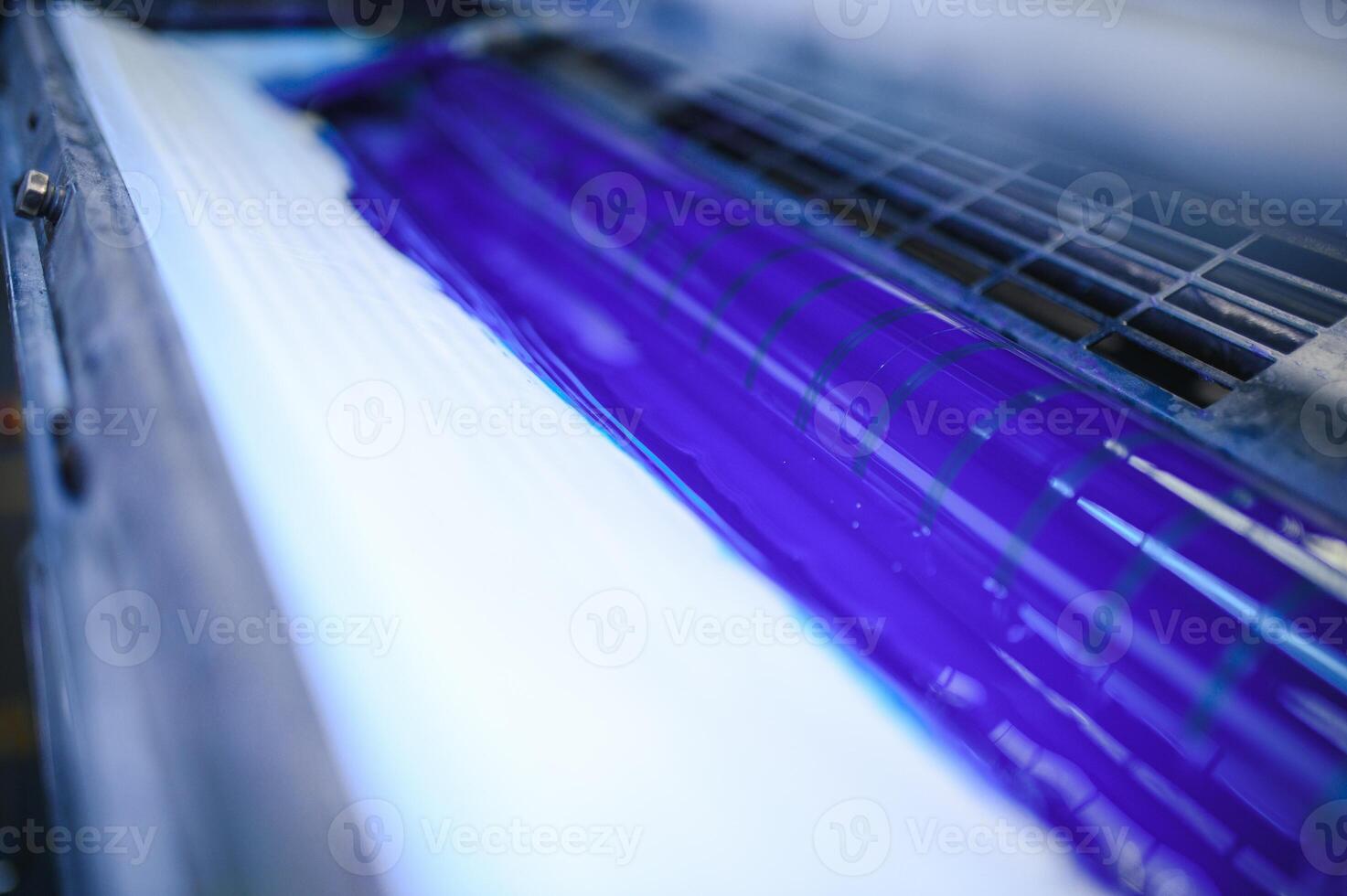blå bläck på rullar av industriell offset skrivare under arbete i typografi verkstad foto