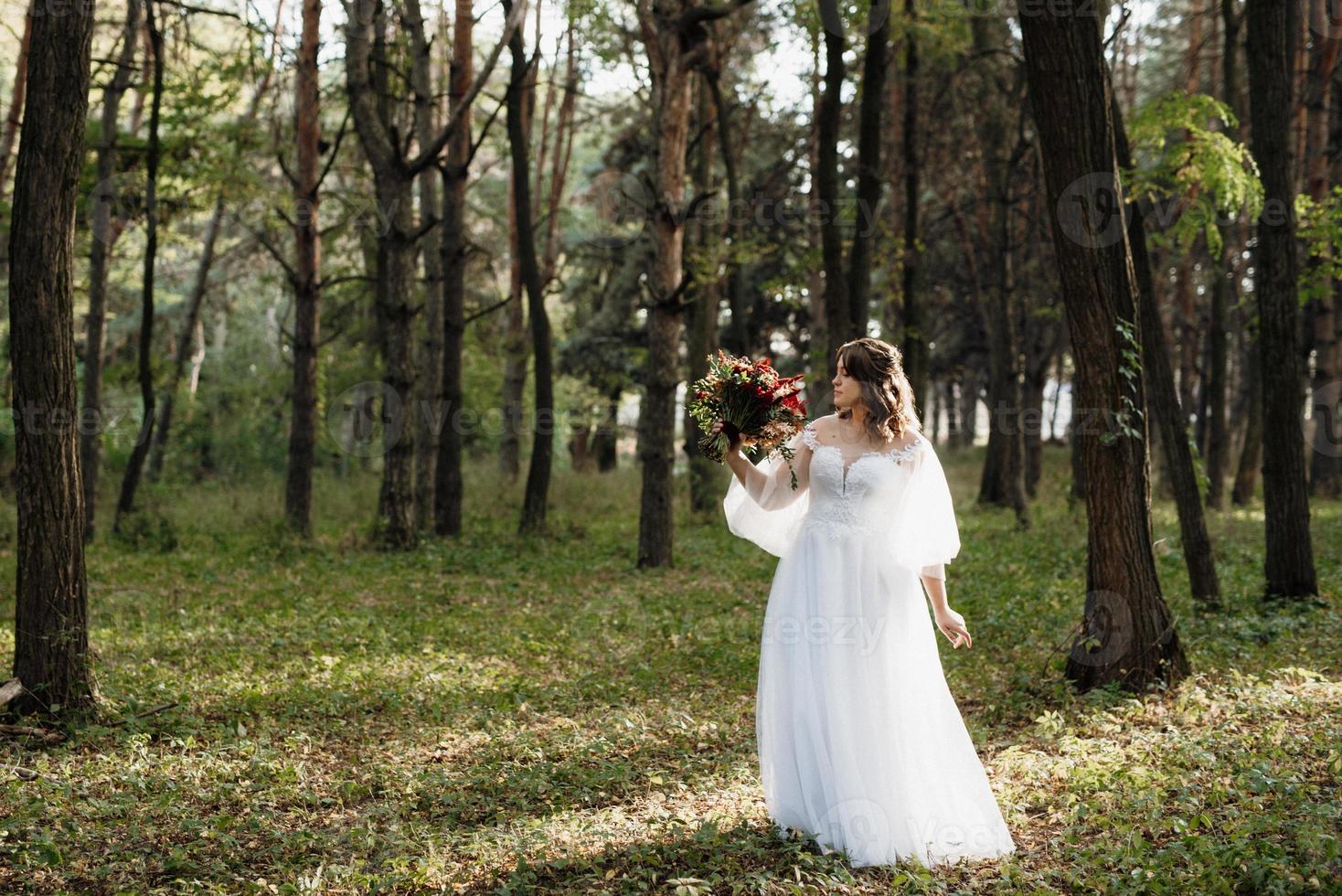 flicka i en bröllopsklänning i höstskogen foto