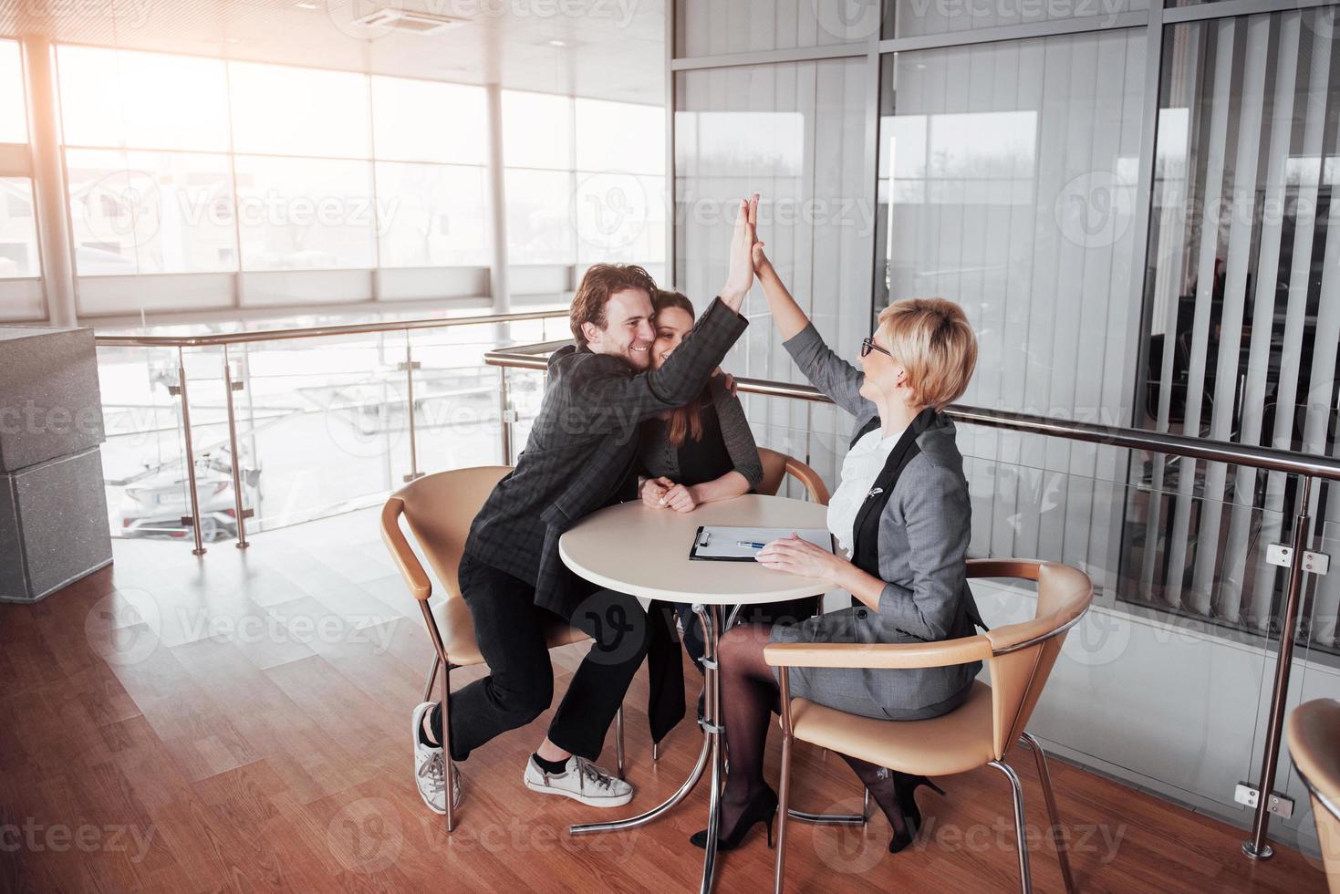 lyckligt framgångsrikt affärsteam som ger en high fives-gest när de skrattar och hejar på framgången foto