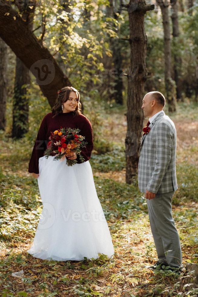 brudparets promenad genom höstskogen foto