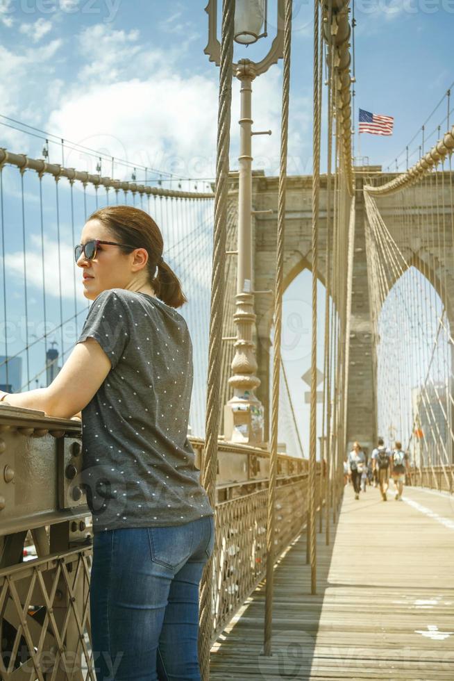 kvinna ser stadsbilden från brooklyn bridge i new york city foto