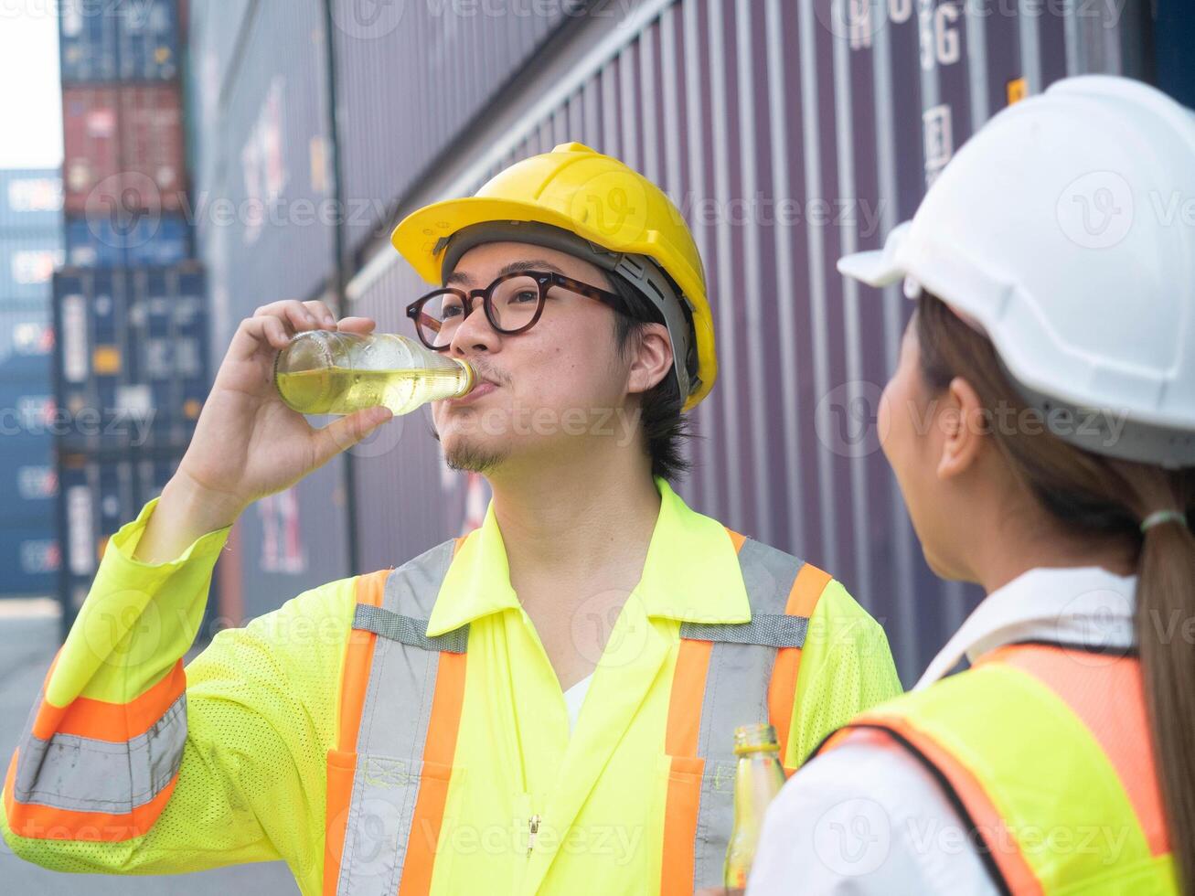 arbetskraft manlig man person människor mänsklig stänga upp ha på sig glasögon gul Hardhat hjälm säkerhet dryck äta vatten vitamin törstig flaska kvinna kvinna lady industri fabrik förfriskning entreprenör behållare läser in foto