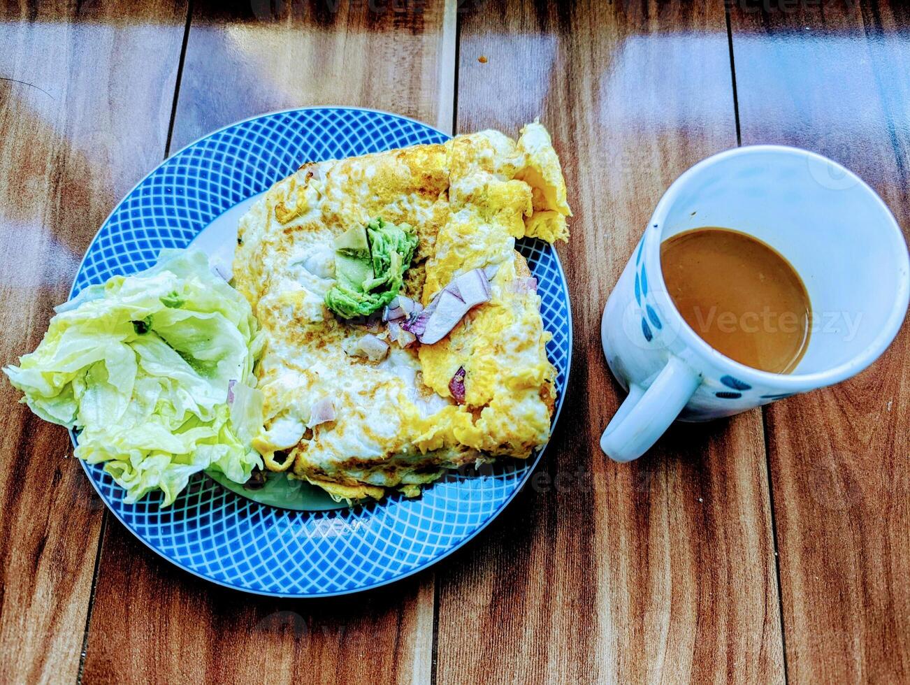 friska frukost med bröd rostat bröd med ägg omelett sallad och en varm kopp av mjölk te. foto