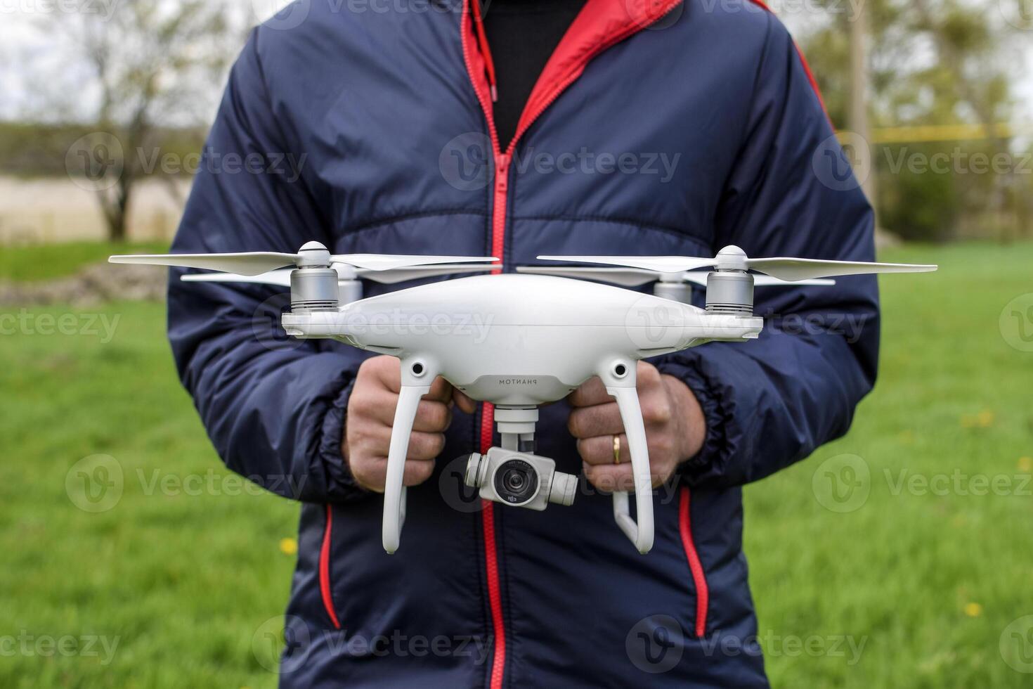 en man med en quadrocopter i hans händer. en vit Drönare är varelse p foto