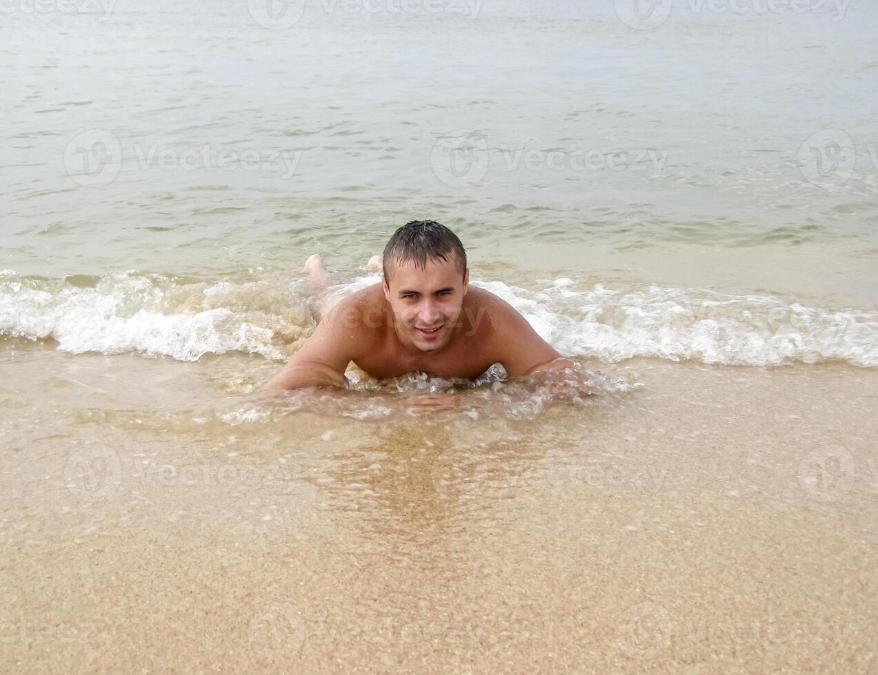 man på de Strand lögner. de hav Vinka omslag de maskulin. strand foto