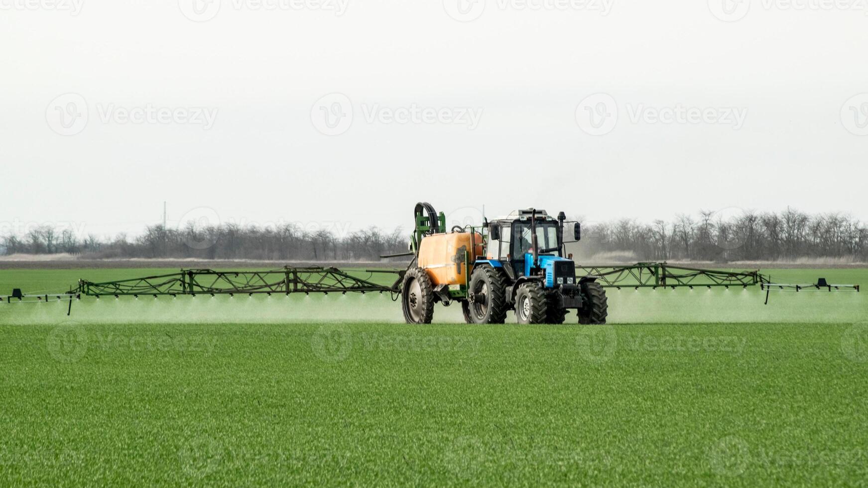 traktor med en spray enhet för fint spridda gödningsmedel. foto