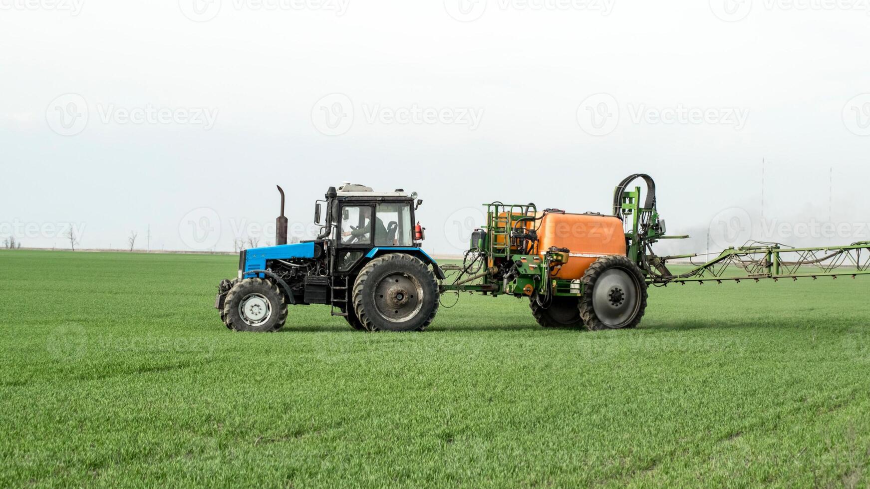 traktor med en spray enhet för fint spridda gödningsmedel. foto