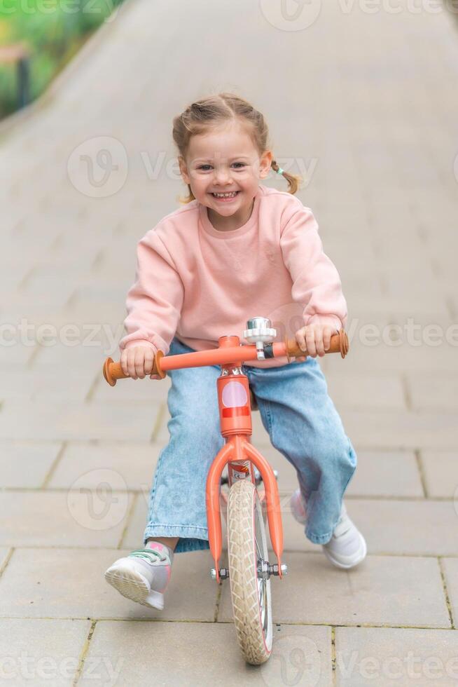 liten flicka ridning balans cykel i de gård av de bostad i Prag, Europa foto