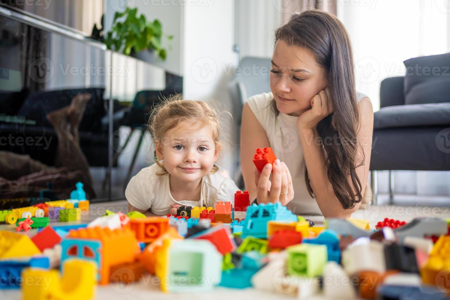 liten flicka spela med konstruktör leksak på golv i Hem med mamma eller kvinna barnvakt, pedagogisk spel, familj på Hem spendera fritid aktiviteter tid tillsammans begrepp foto