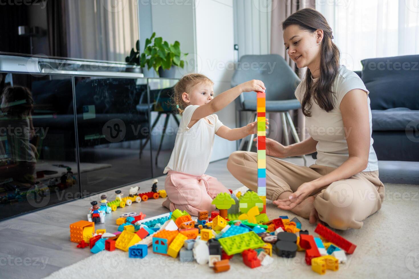 liten flicka spela med konstruktör leksak på golv i Hem med mamma eller kvinna barnvakt, pedagogisk spel, familj på Hem spendera fritid aktiviteter tid tillsammans begrepp foto