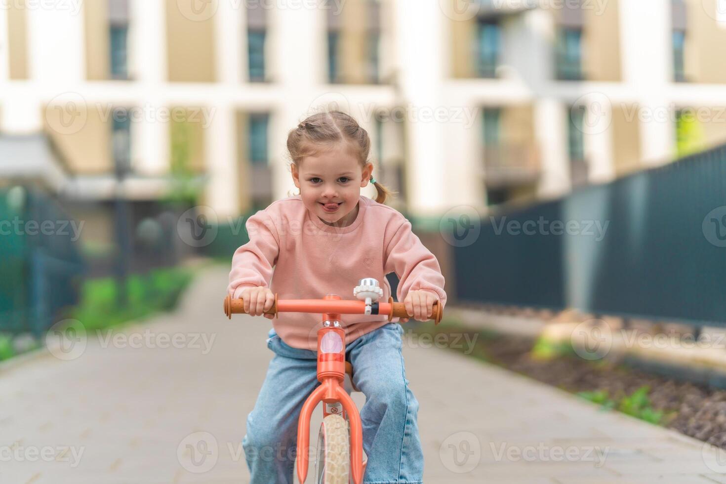 liten flicka ridning balans cykel i de gård av de bostad i Prag, Europa foto