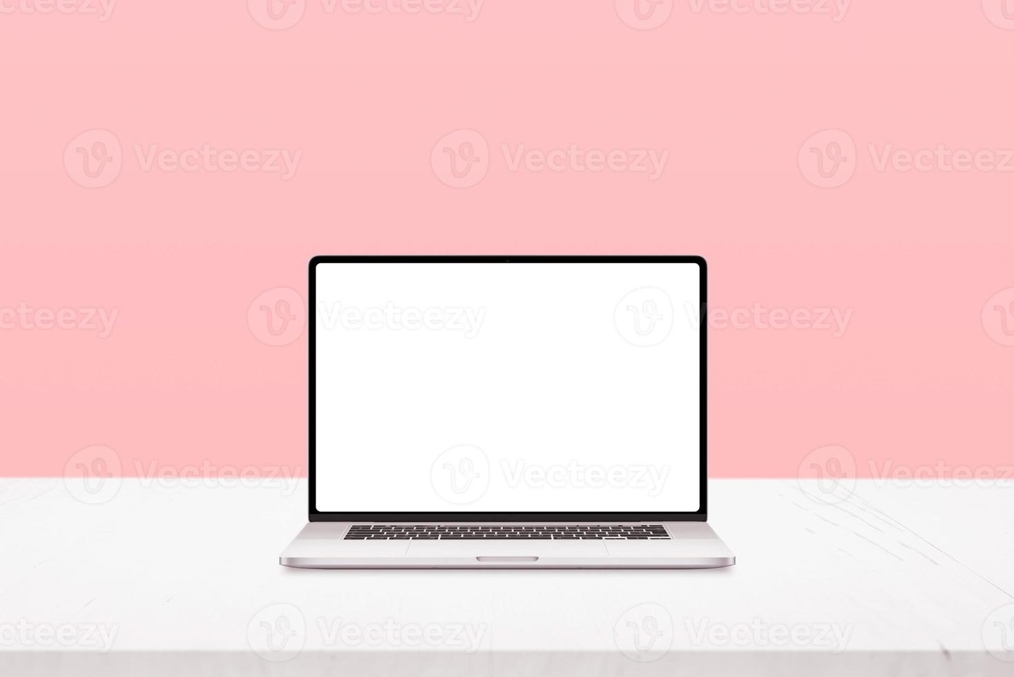 laptop mockup på vitt skrivbord med pastellrosa bakgrund foto