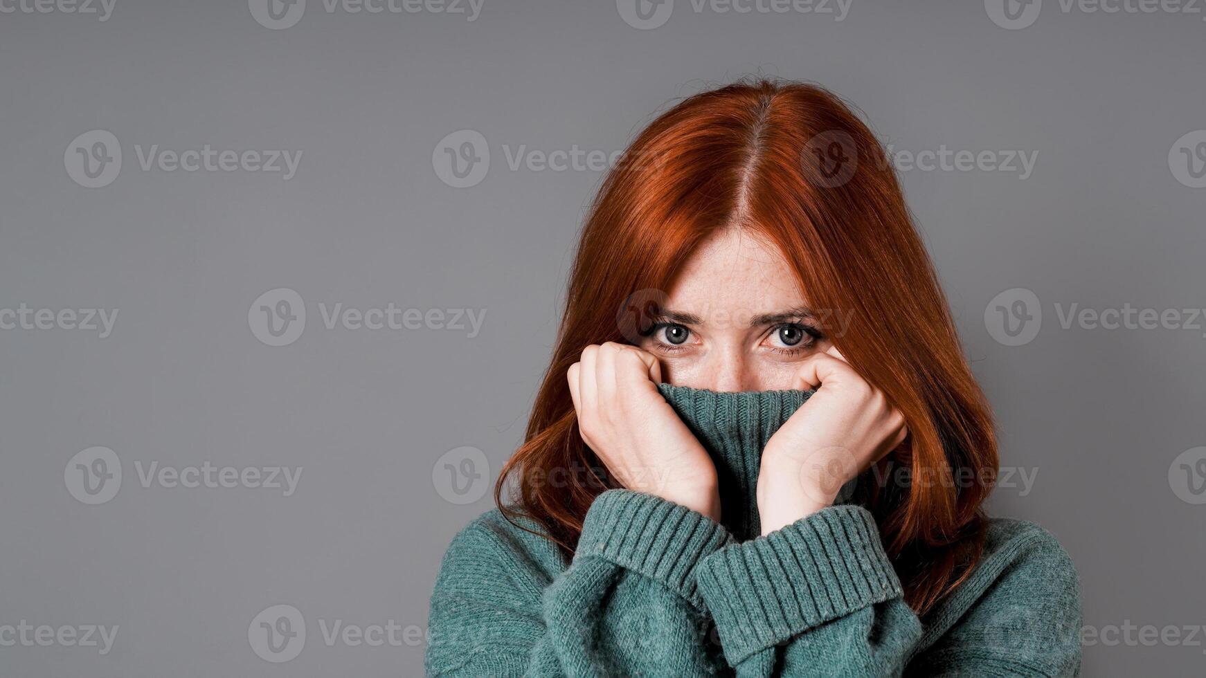 blyg eller generad kvinna dragande turtleneck Tröja över ansikte foto