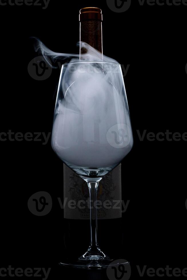 silhuett av vin glas flaska full av rök i svart bakgrund foto