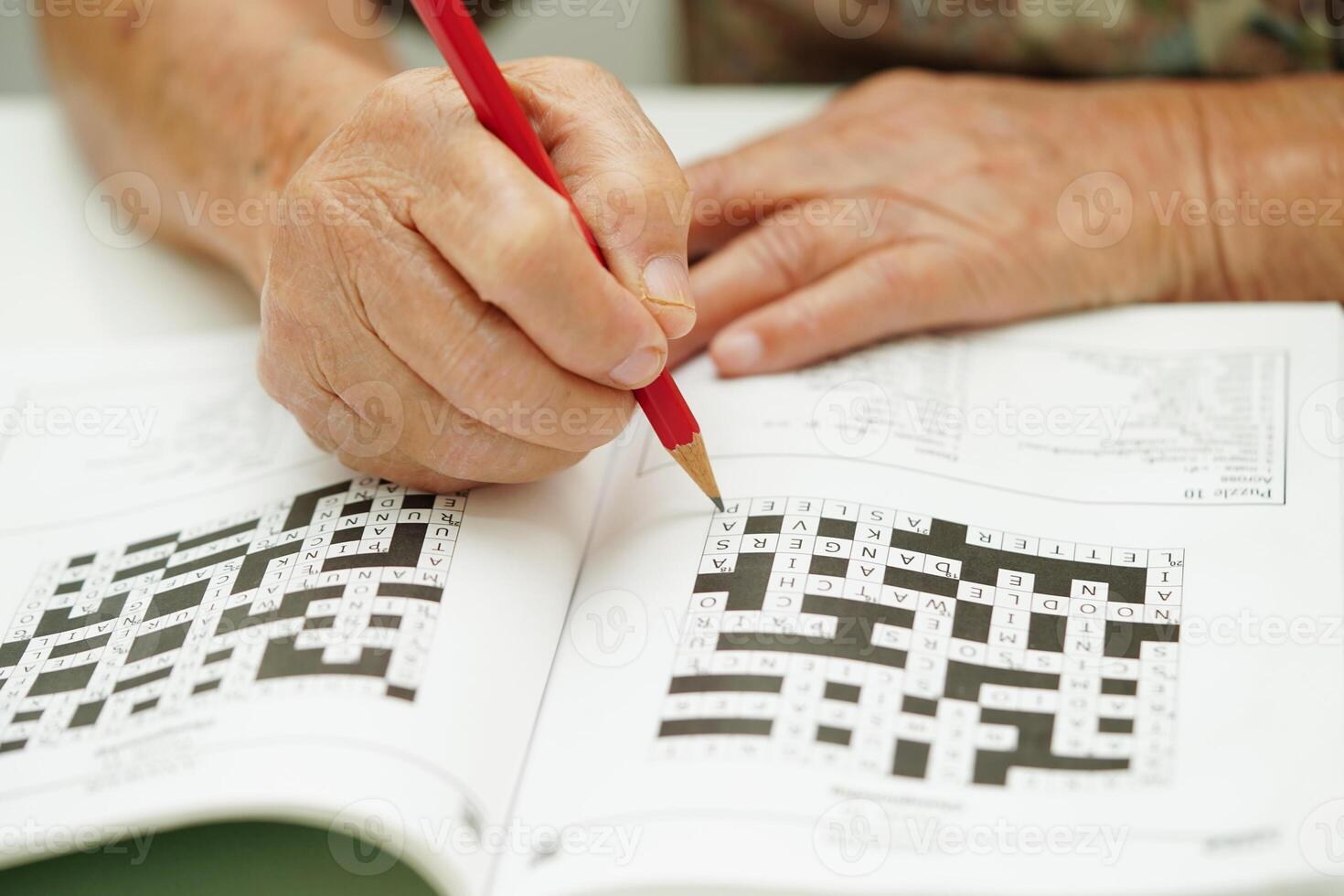 äldre kvinna spelar sudoku pussel spel för behandling demens förebyggande och alzheimers sjukdom. foto