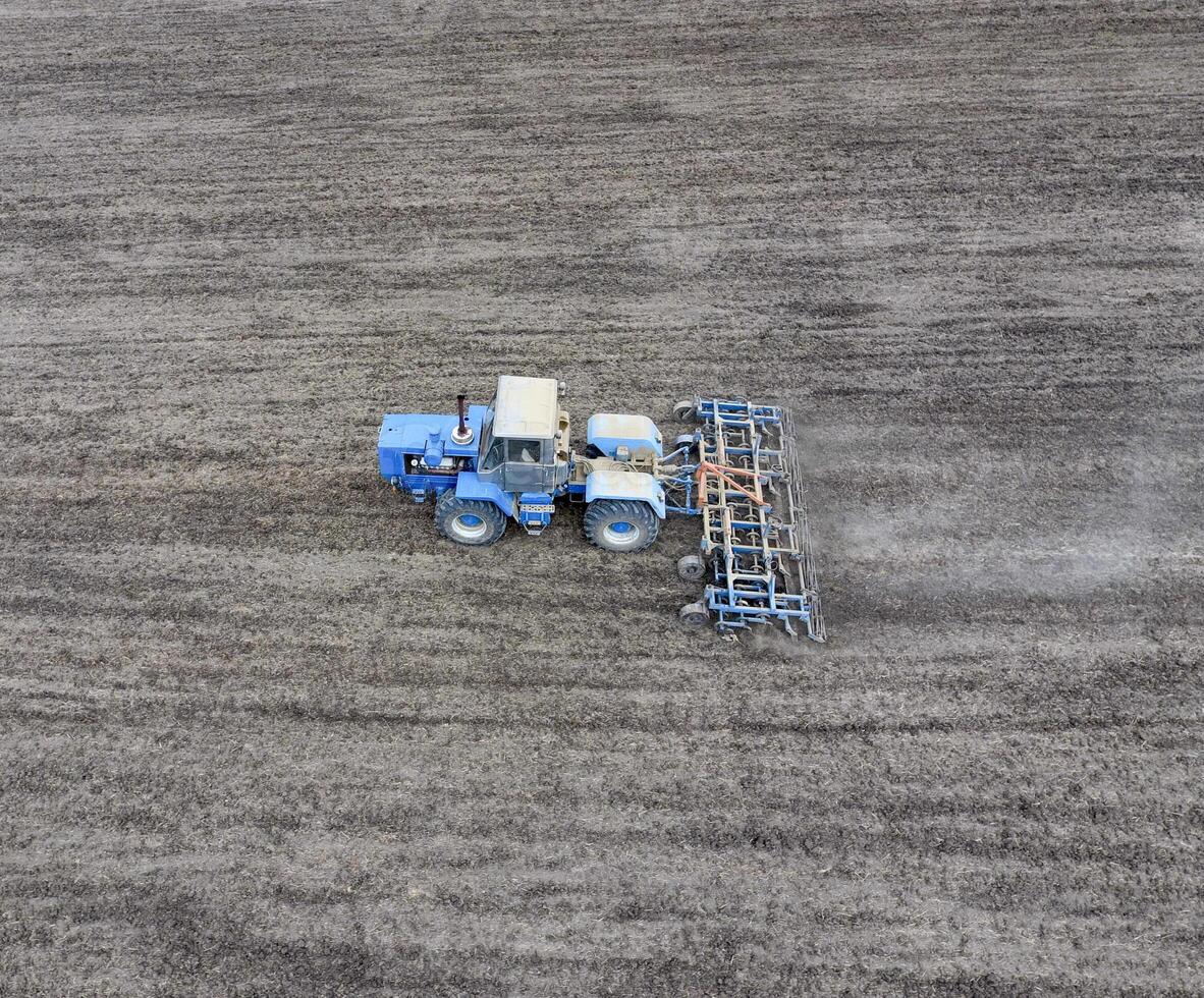 de traktor plogar de fält. under sådd, de jord är lossnade på de fält. foto