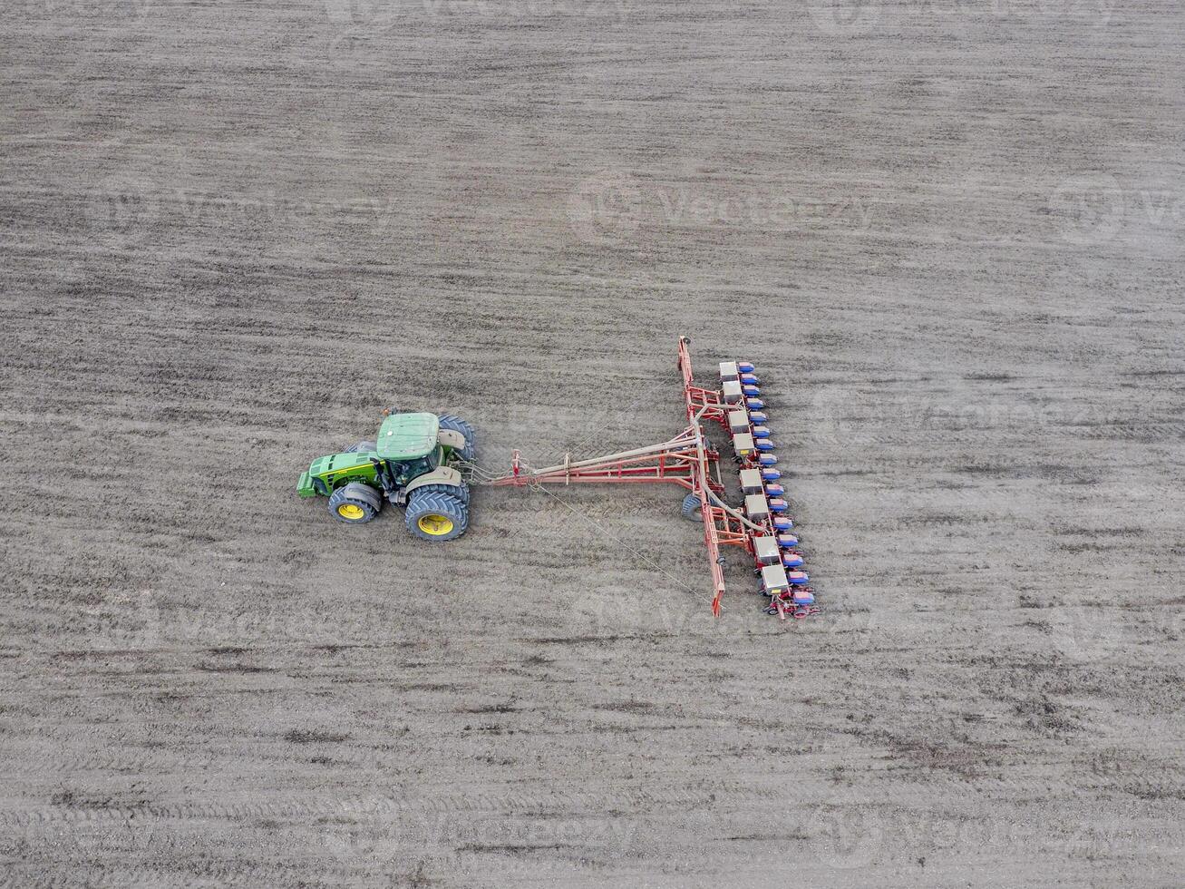 sådd av majs. traktor med en såmaskin på de fält. använder sig av en såmaskin för plantering majs. foto