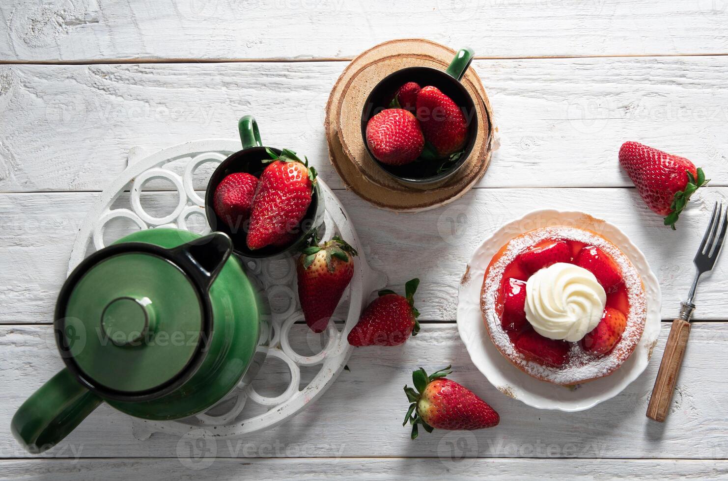 frukt fortfarande liv med jordgubbar och grön te uppsättning, jordgubb kaka med grädde foto