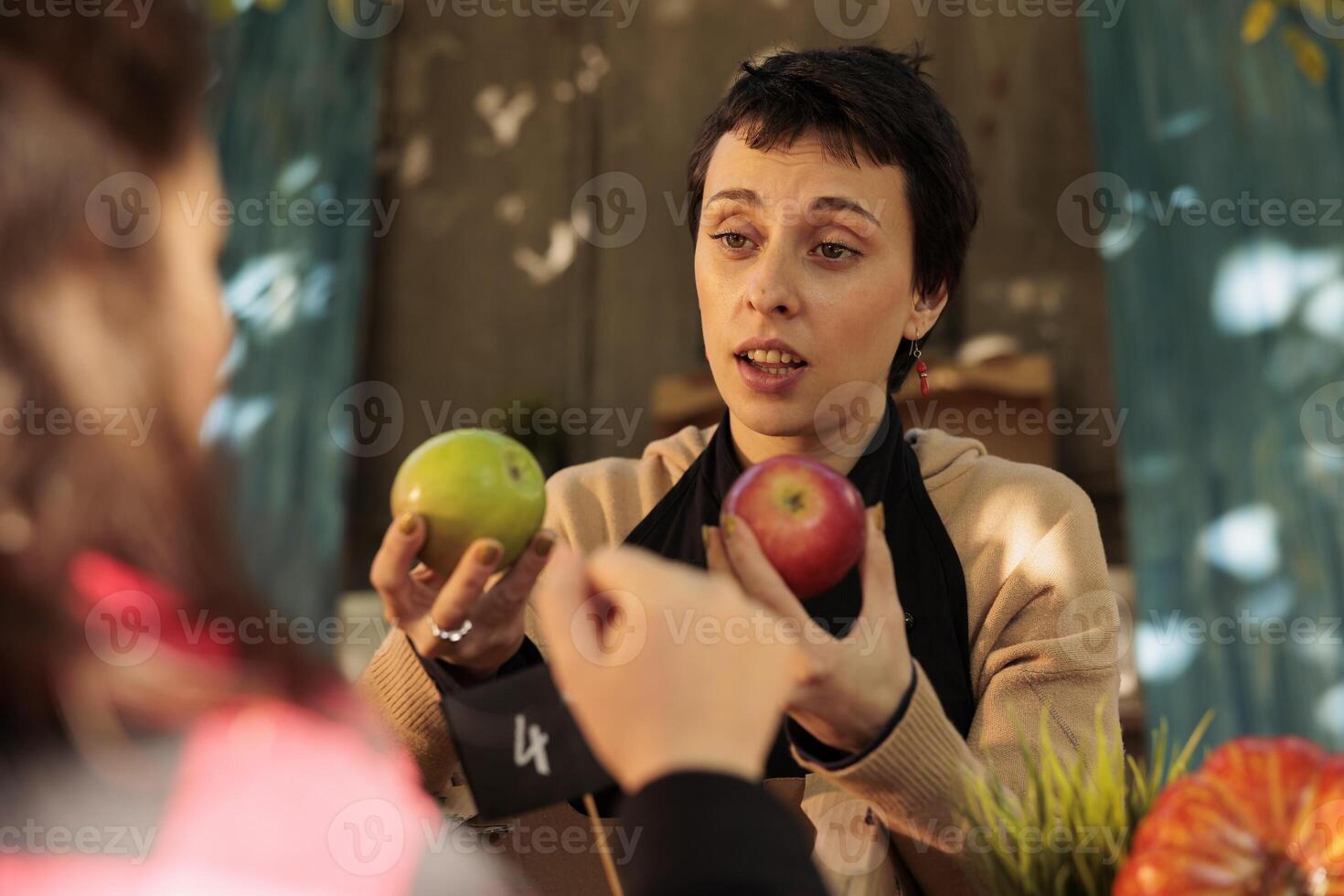 jordbrukare marknadsföra säljare lukta röd äpplen på marknad, försäljning färsk organisk frukt och grönsaker till kund. ung glad kvinna uppköp lokalt vuxen friska mat och bio producera. foto