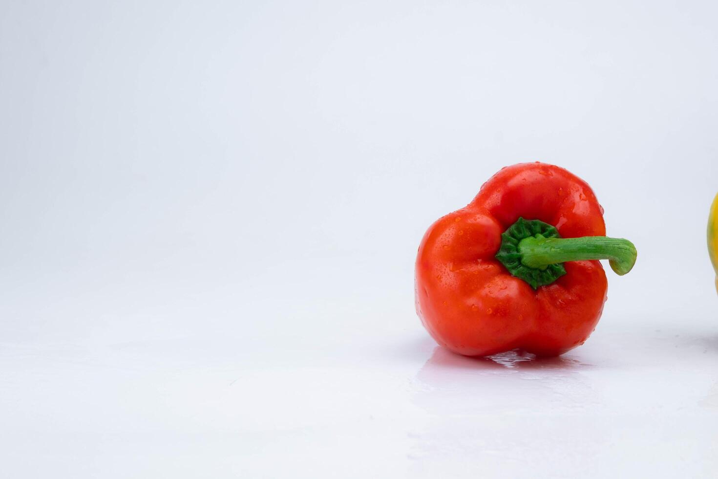 färsk röd klocka peppar med vatten droppar isolerat på vit bakgrund. foto