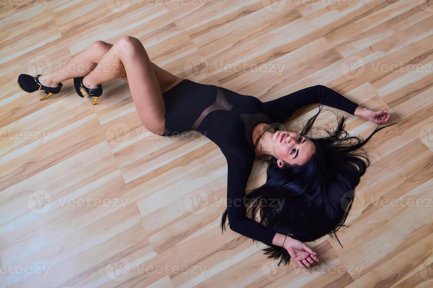 flicka brunett i en svart klänning lägga på de golv foto