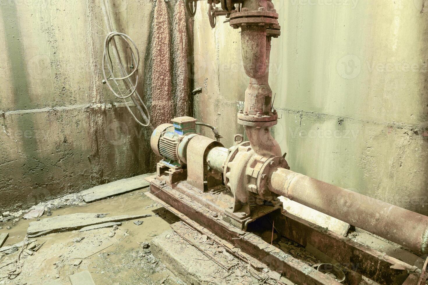 gammal rostig pump i de källare. källare av en vatten pumpning statistik foto