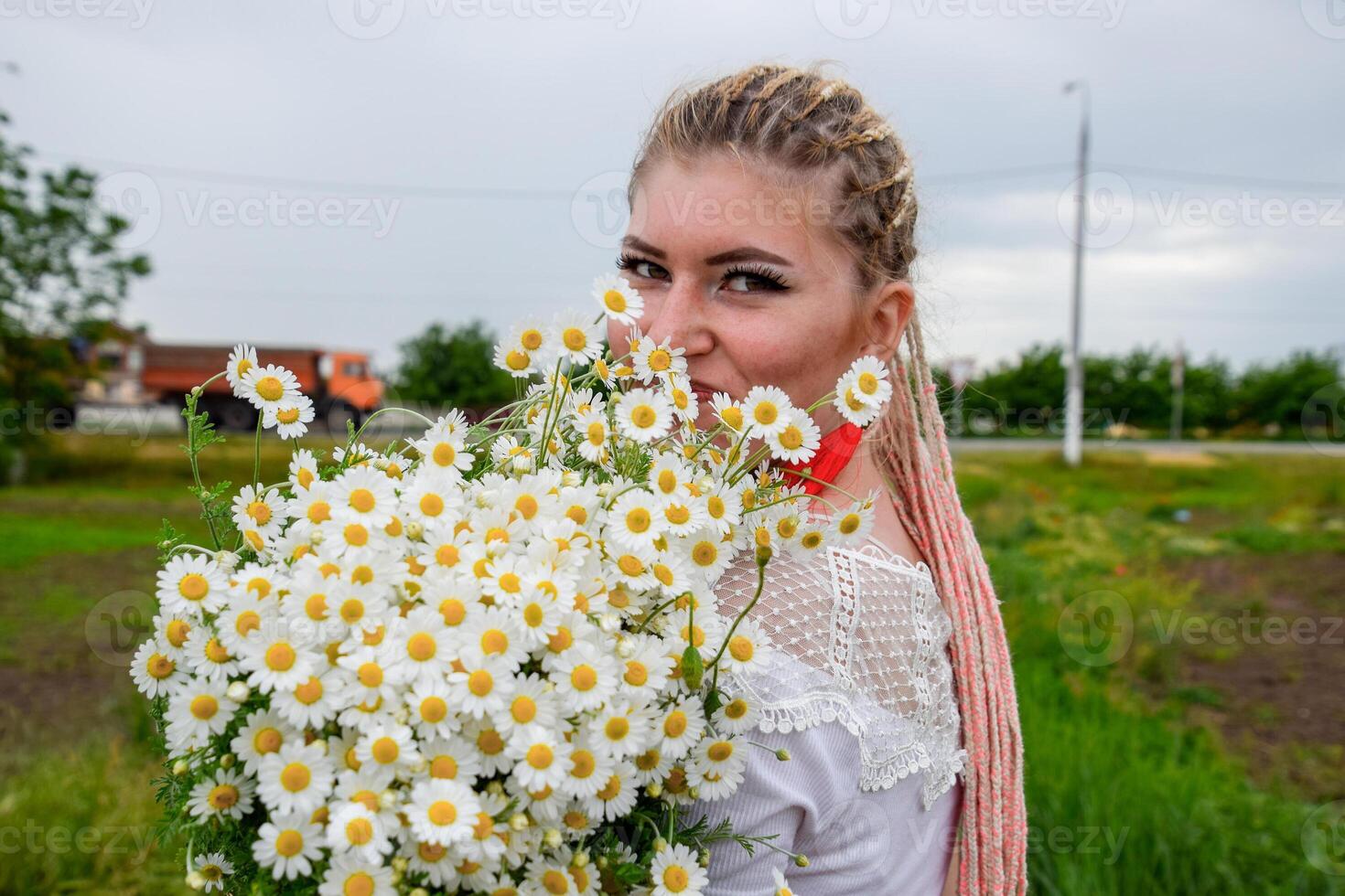ung flicka med en bukett av daisy i fält. daisy på en vallmo fält. foto