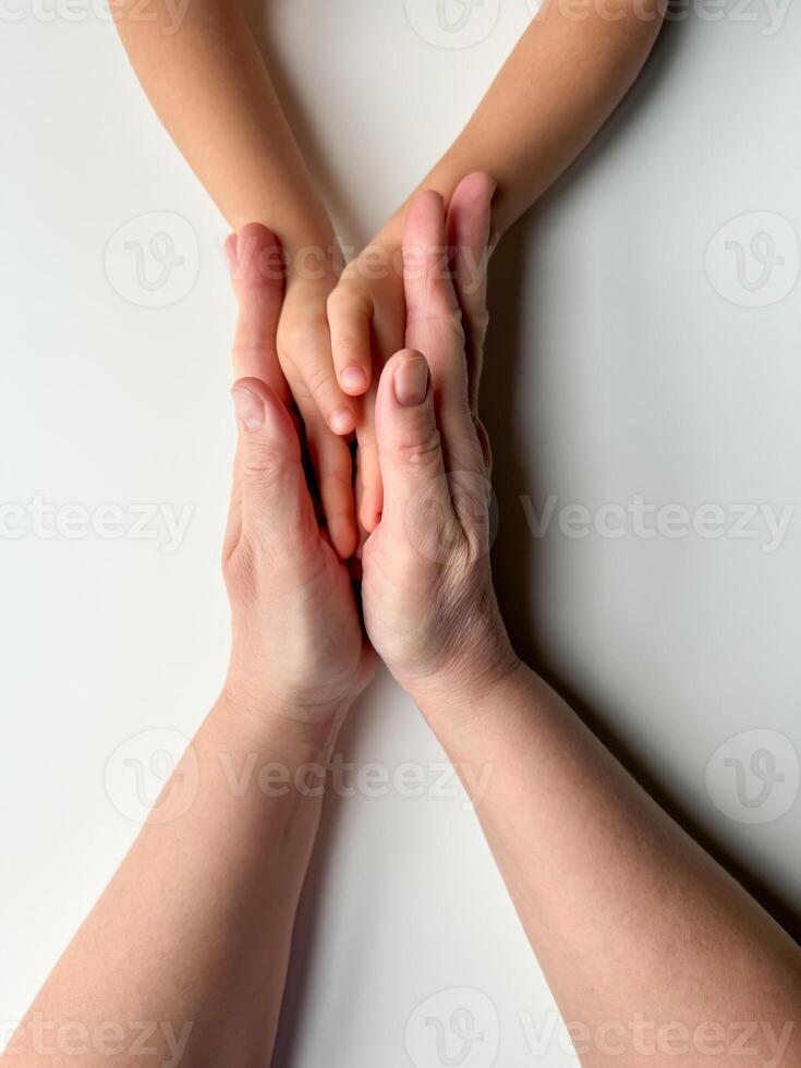 mödrar händer innehav childs händer på vit bakgrund. foto