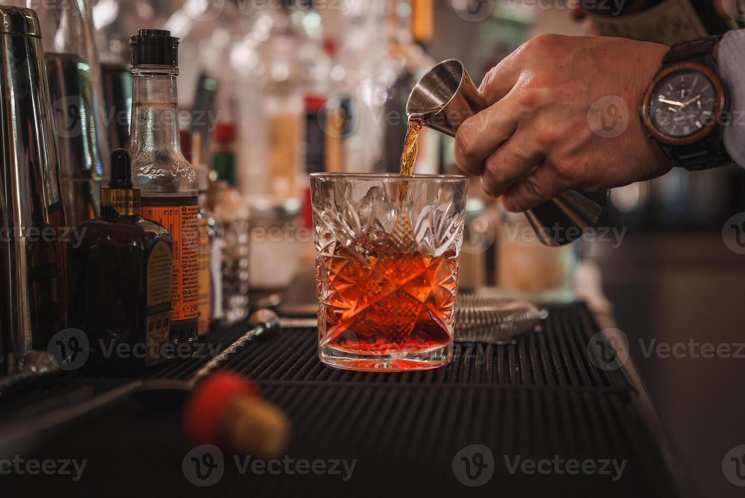 venetian bartender häller lyxig alkoholhaltig dryck in i Martini glas i eleganta miljö foto