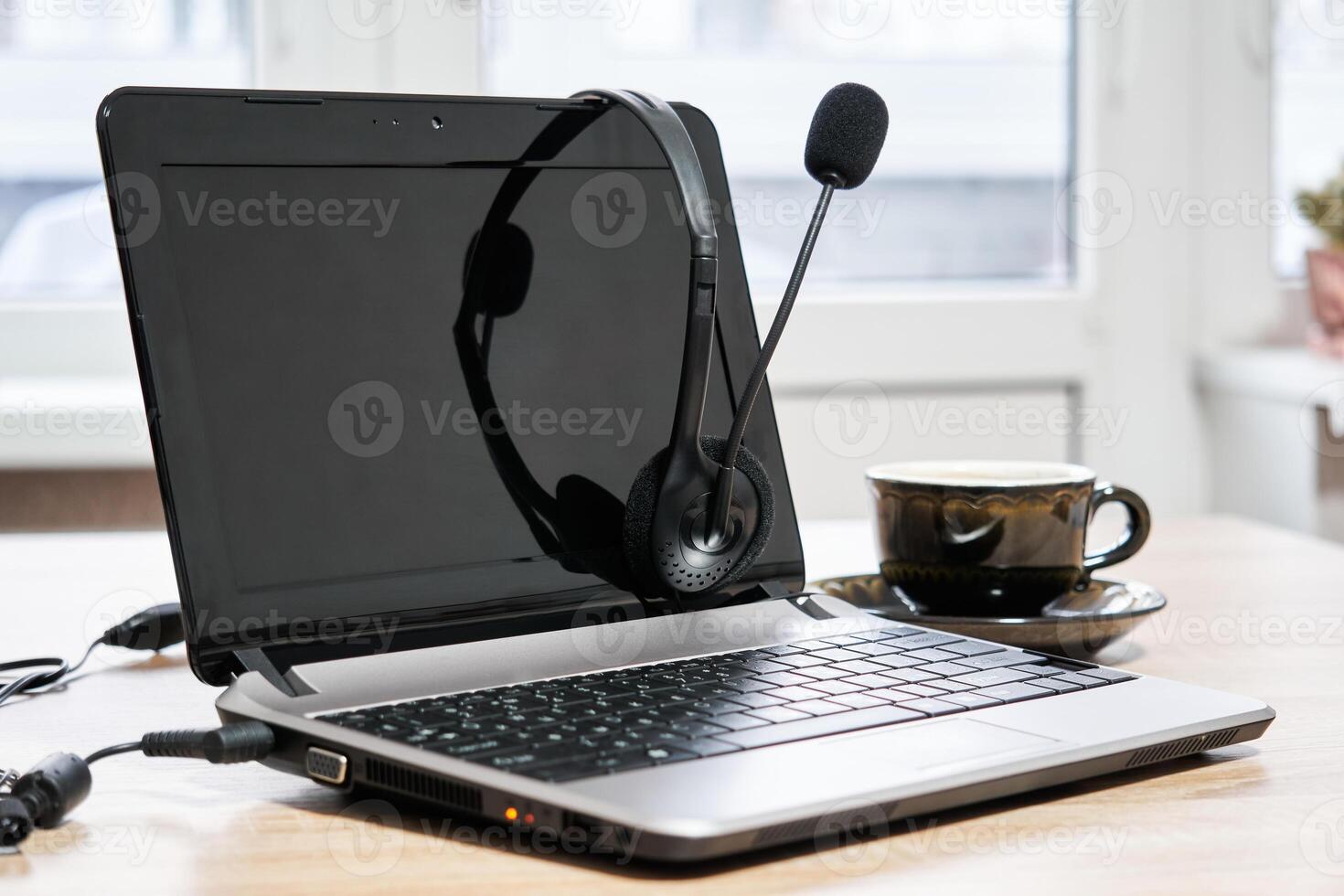 bärbar dator med hörlurar och kopp av kaffe på de tabell närbild foto
