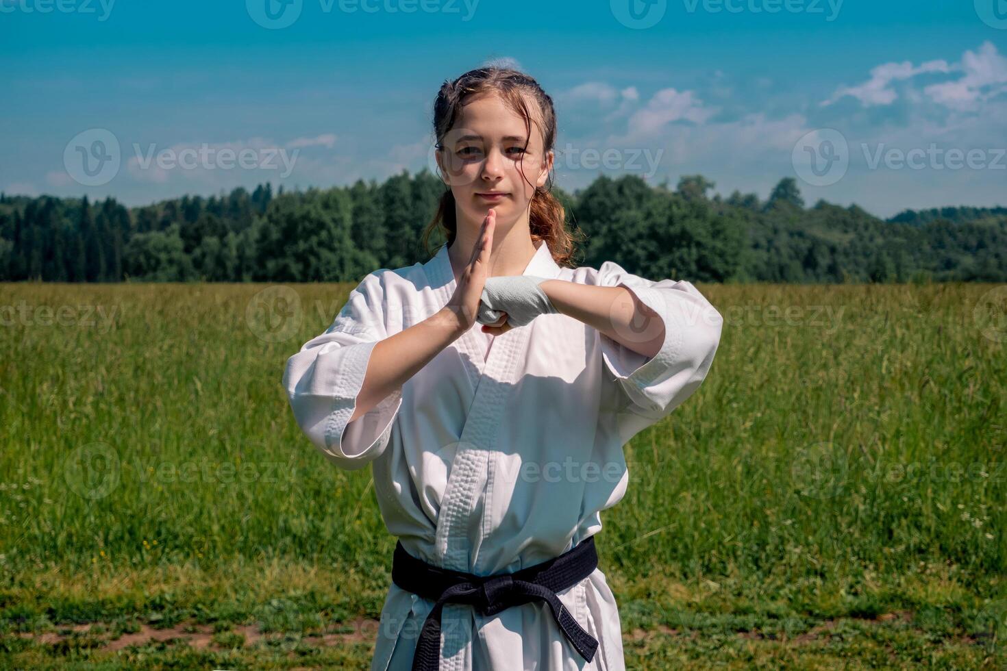 Tonårs flicka Träning karate kata utomhus, hälsningar oss foto