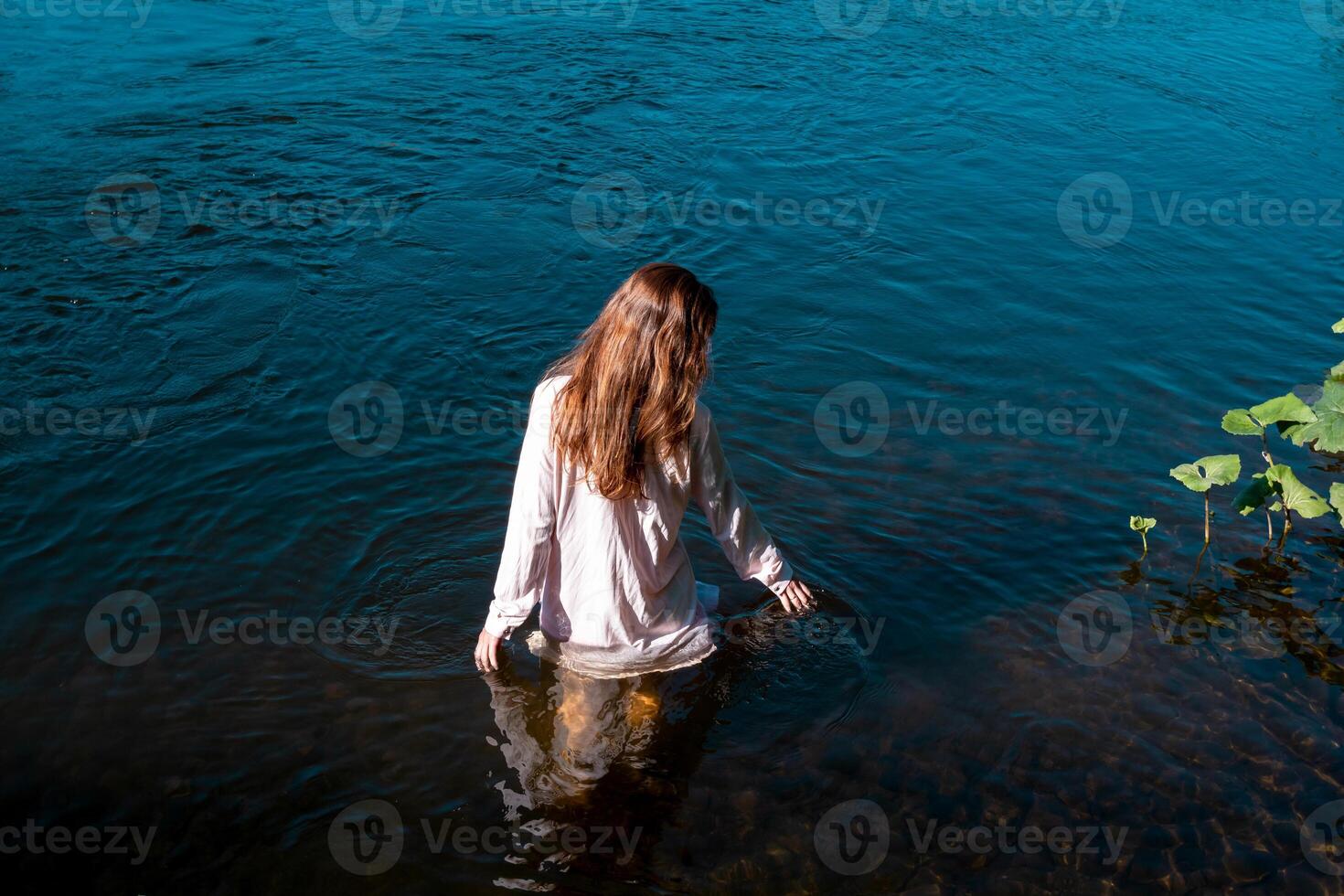 ung kvinna badar i de flod njuter de Häftigt vatten foto