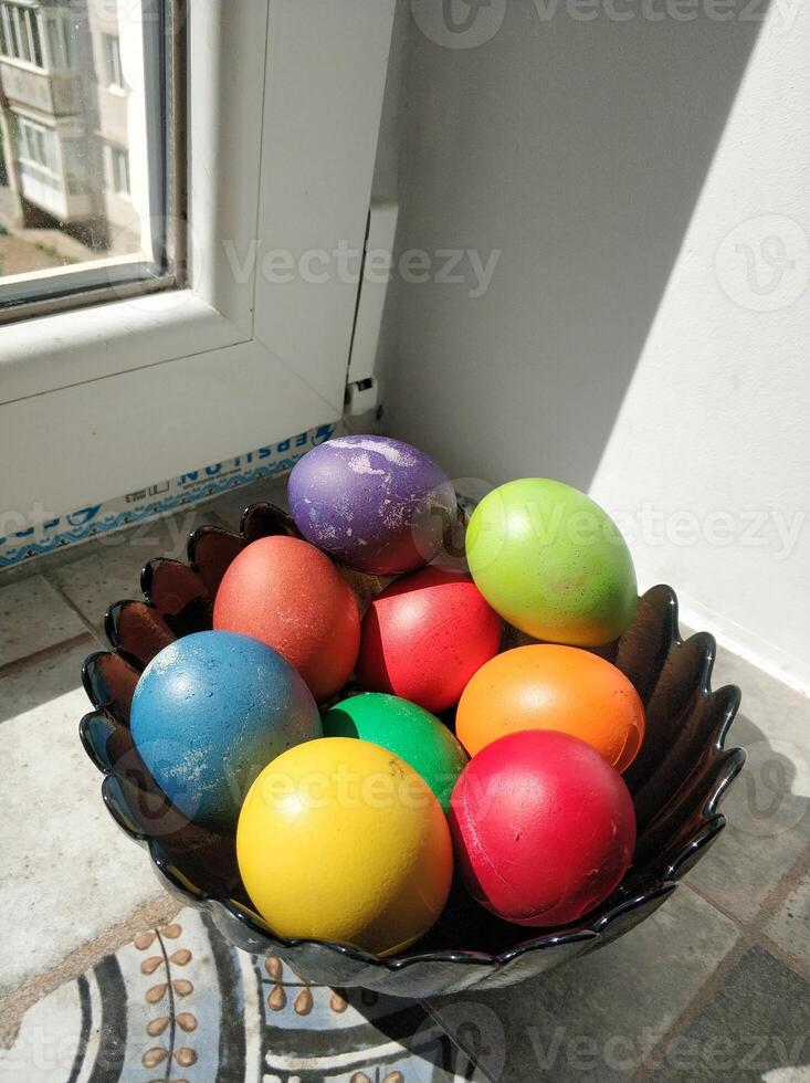 flerfärgad ägg i en svart tallrik för de påsk Semester foto