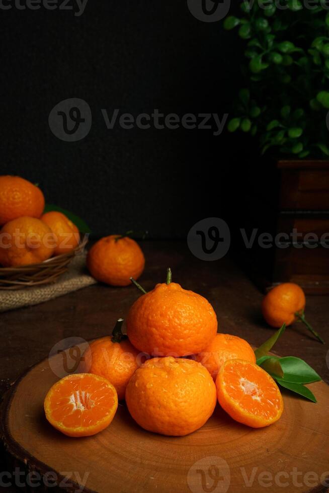 färsk orange frukt stänga upp skott. filmiska stil, mörk humör fotografi. orange frukt på de skärande styrelse foto