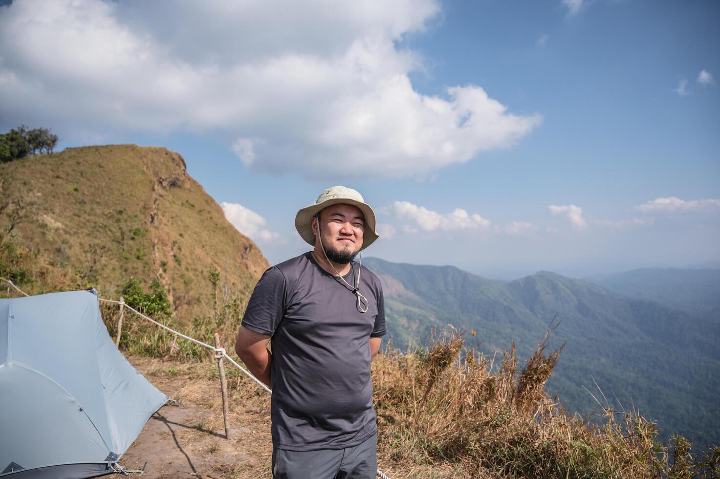 asiatisk fett man med skön se av khao san nok wua berg kanchanaburi.khao san nok wua är de högsta berg i khao laem nationell parkera. den är 1767 meter ovan hav nivå. foto